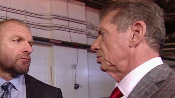 Triple H looking angrily at Vince McMahon